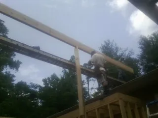 Carpenter setting a ridge beam over a new addition frame — Ice Dam Removal by Roofing Brothers in Romeoville