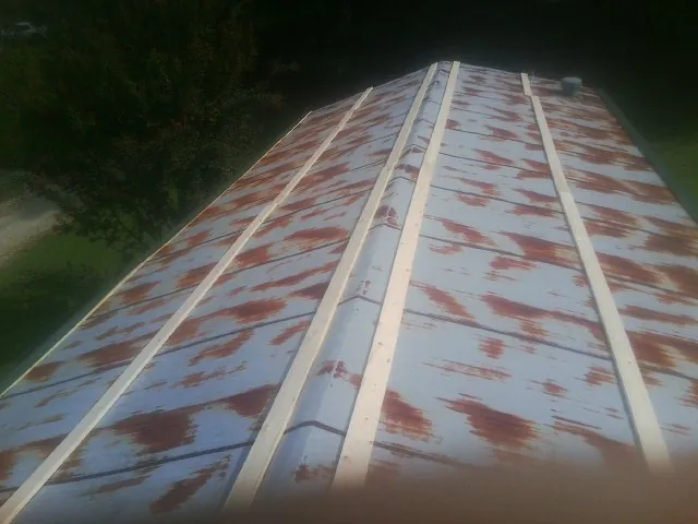 Rusted metal roof panels with new wood purlins before replacement — Storm Damage Roof Repair in Romeoville by Roofing Brothers