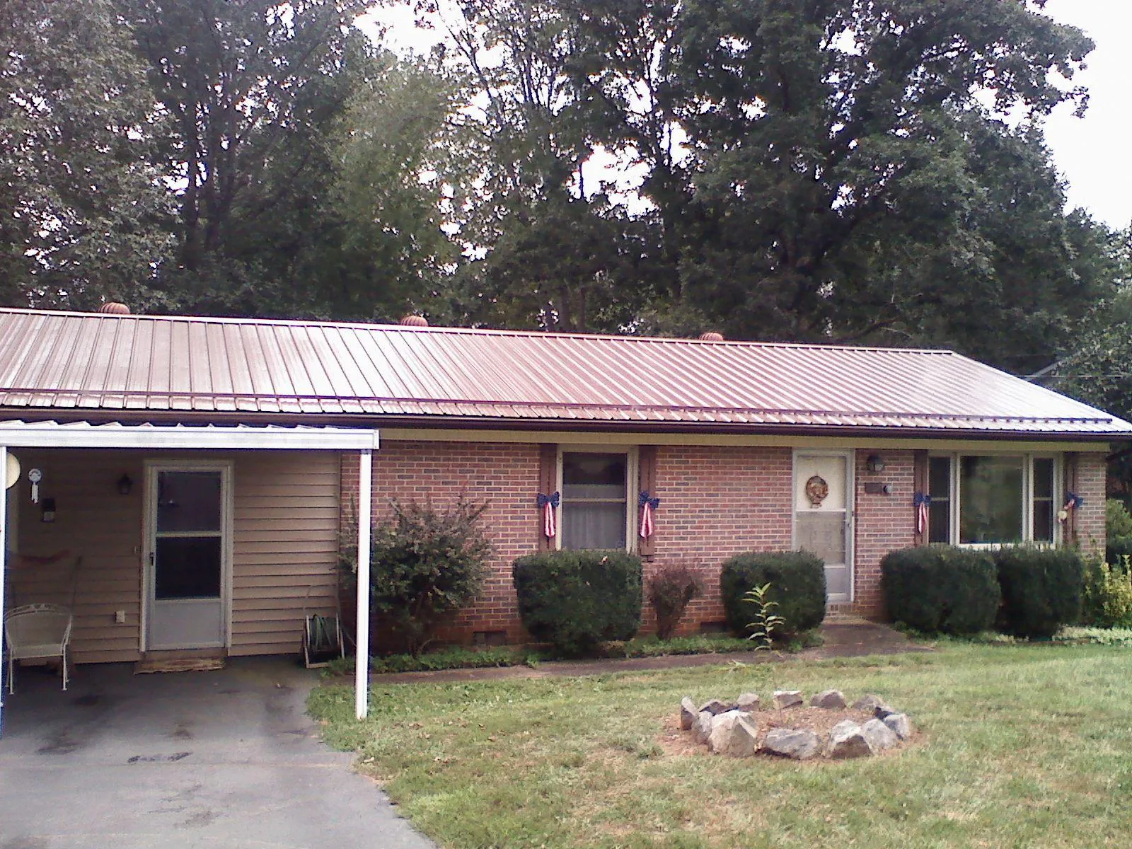 Bronze metal roof and carport on a brick ranch home — Roof Repair work by our crew in Romeoville